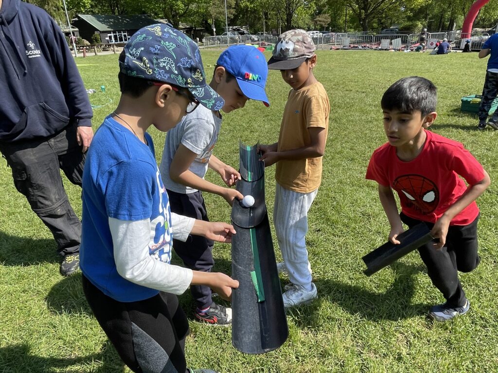 boys following a ball down a pipe